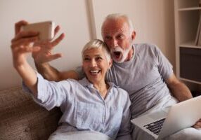 Senior couple making a selfie in bed.